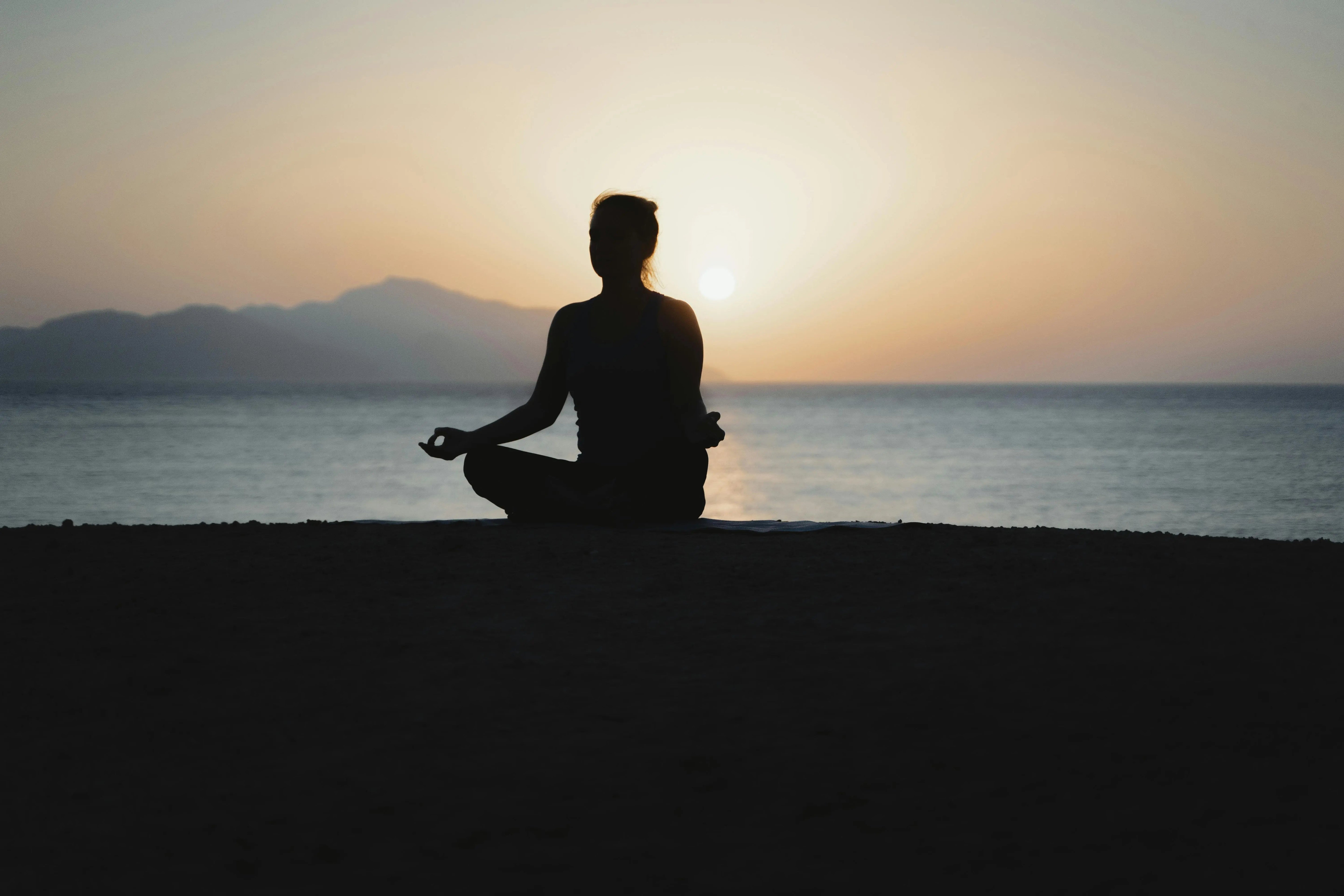 a person relaxing on the beach with a sunset background