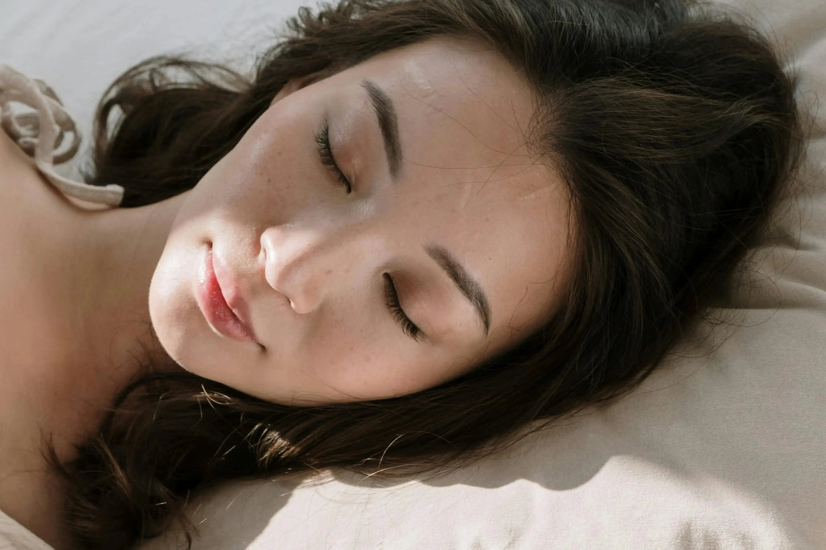 a woman sleeping soundly with a pillow
