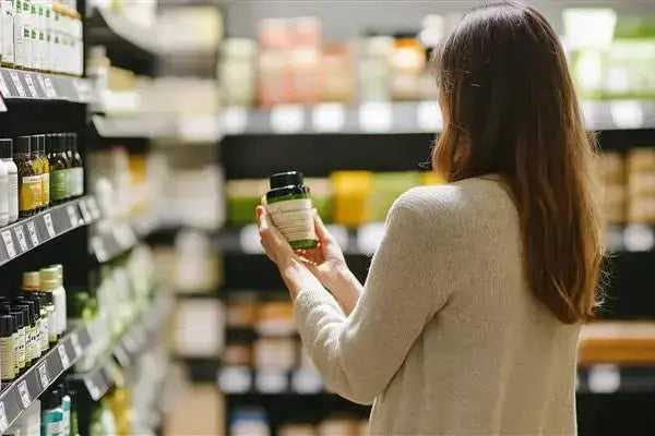 a person in a supermarket trying to buy a supplement