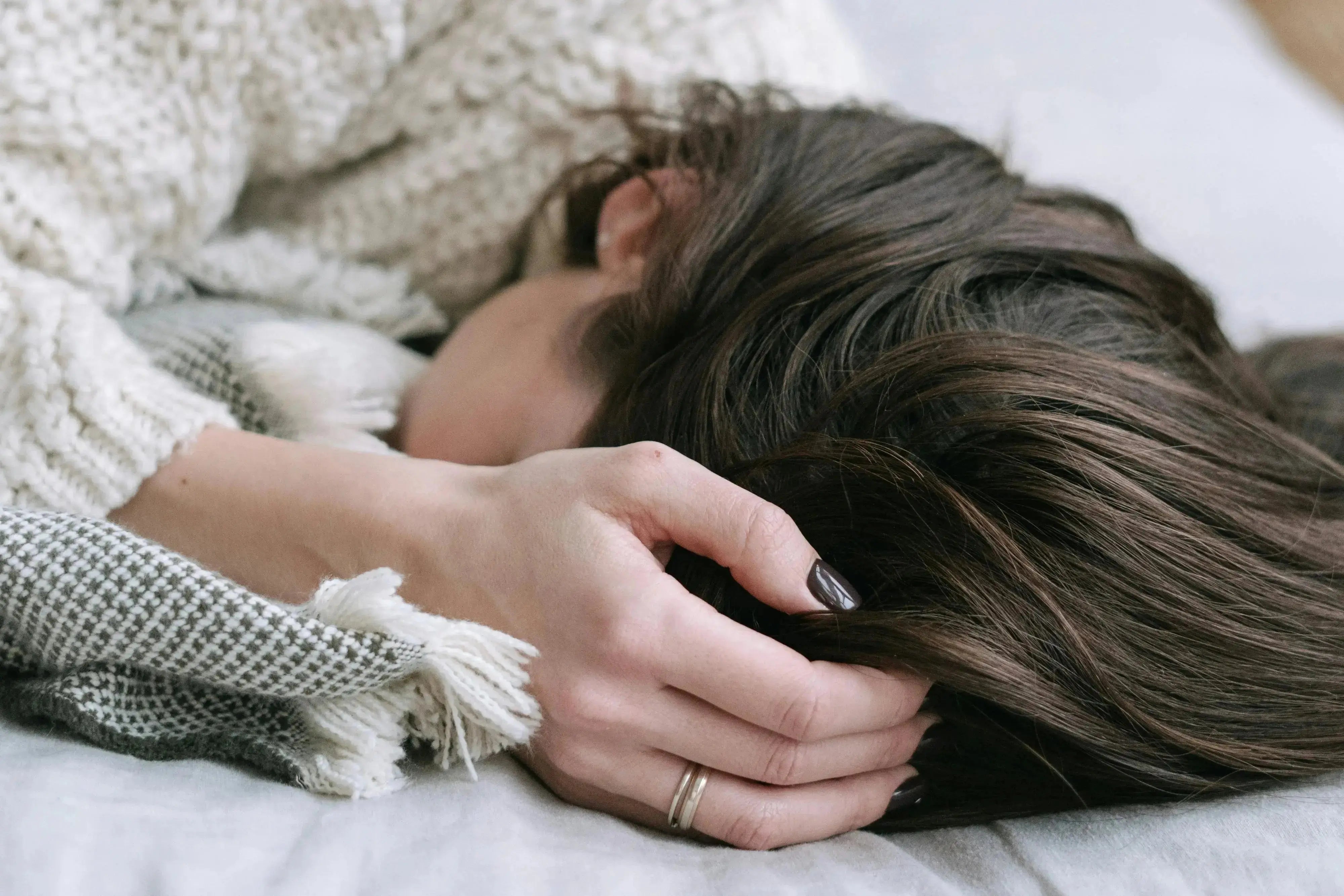 a person with their hand on their head trying to sleep